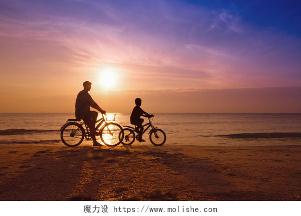 父亲和儿子在海滩上落日下骑自行车的人的家庭剪影